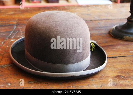Close-up of an antique bowler hat, with a feather in the hatband. Stock Photo