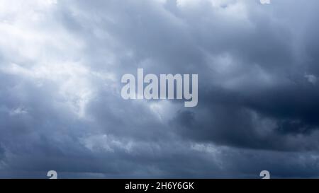 Dark storm clouds make the sky in black. The rain is coming soon. Beautiful heaven with dramatic light, sometimes heavy clouds mass charged. Abstract Stock Photo