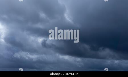 Dark storm clouds make the sky in black. The rain is coming soon. Beautiful heaven with dramatic light, sometimes heavy clouds mass charged. Abstract Stock Photo