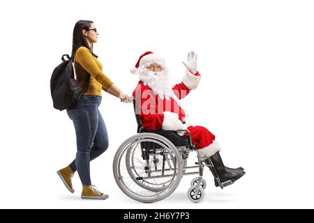 Female student walking and pushing cheerful santa claus in a wheelchair isolated on white background Stock Photo