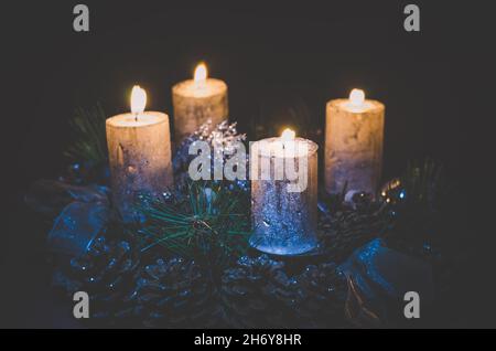 advent concept with four silver burning candle on black background Stock Photo