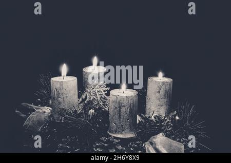 advent concept with four silver burning candle on black background Stock Photo