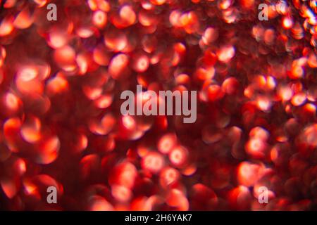 Texture created from oval red objects. The effect was obtained by photographing the glitter surface in a macro scale without focusing. Stock Photo