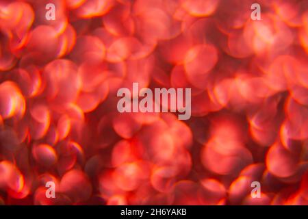 Texture created from oval red objects. The effect was obtained by photographing the glitter surface in a macro scale without focusing. Stock Photo