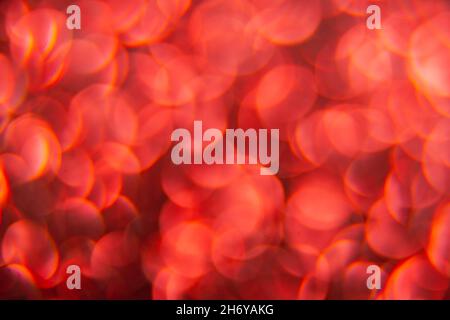 Texture created from oval red objects. The effect was obtained by photographing the glitter surface in a macro scale without focusing. Stock Photo