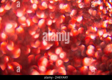 Texture created from oval red objects. The effect was obtained by photographing the glitter surface in a macro scale without focusing. Stock Photo
