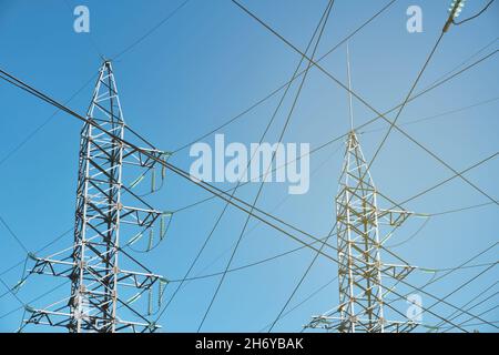 High-voltage power line against blue sky Stock Photo