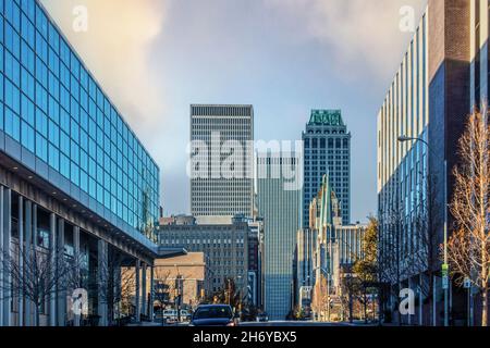 Streets of Tulsa with strange lights casting colored shadows on both sides of street leading to tall skyscrapers at the end - winter scene Stock Photo