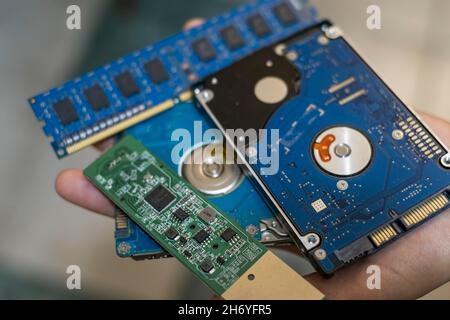 Nerd man hold electronic micro chip integrated circuit motherboard and data storage devices,computer components shortage Stock Photo