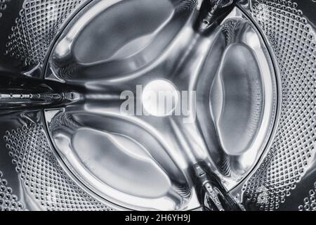 Washing machine drum inside, silver-colored steel background Stock Photo