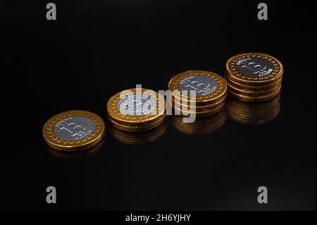 Stack of physical bitcoin crypto currency coins on an isolated black background Stock Photo