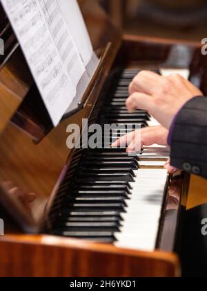 pianist plays vigorously on the piano keys, close-up view, musical score Stock Photo