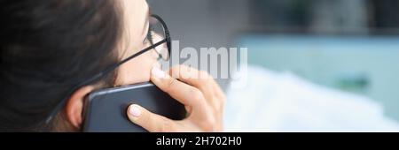 Businesswoman talking on smartphone and reading document solving corporate business problems Stock Photo