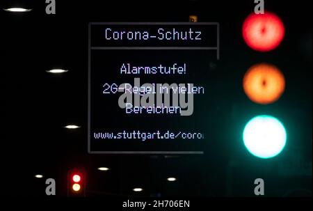 Stuttgart, Germany. 19th Nov, 2021. A display indicates the Corona alert level '2G rule in many areas!' in the city centre, while a traffic light changes from red to green. Since November 17, 2021, the Corona alert level has been in effect in Baden-Württemberg, where unvaccinated people are largely excluded from participating in many recreational, cultural and sporting events. Credit: Marijan Murat/dpa/Alamy Live News Stock Photo