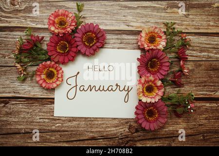 Hello January typography text with flowers on wooden background Stock Photo