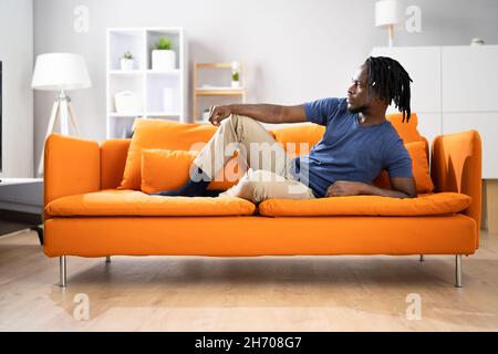 African American Man Relaxing On Sofa Or Couch Stock Photo