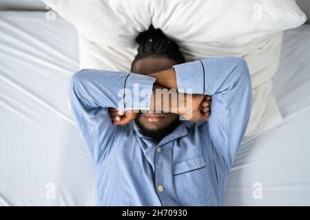 Young Man Suffering From Insomnia Lying In His Bed Stock Photo