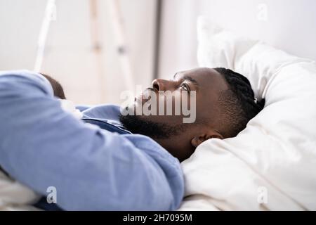 Young Man Suffering From Insomnia Lying In His Bed Stock Photo