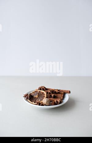 Christmas gingerbread in the shape of stars and spices on a saucer on a white table. Selective focus. Stock Photo