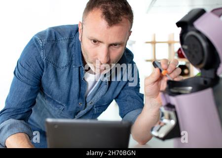 A man is repairing a broken coffee machine in a cafe. There is steam, wrong  work. Support and repair. Stock Photo by ©fransz 171320518