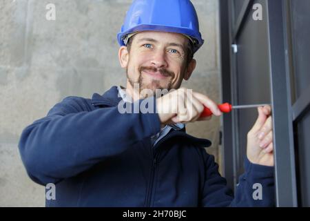 hand screwing a screw into electronic device with the screwdriver Stock Photo