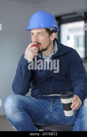 young construction worker eating an apple Stock Photo