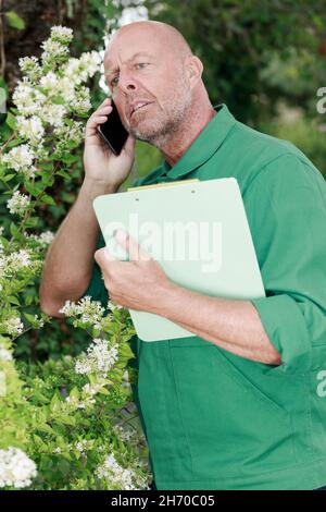 mature man using phone in the garden Stock Photo