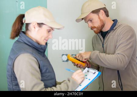 male and female electricians at work at new construction site Stock Photo
