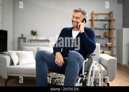 Older Man With Disability Using Smartphone Or Mobile Phone Stock Photo