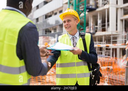 Architect and engineer construction workers shaking hands while working for teamwork  Stock Photo