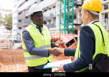 Architect and engineer construction workers shaking hands while working  Stock Photo