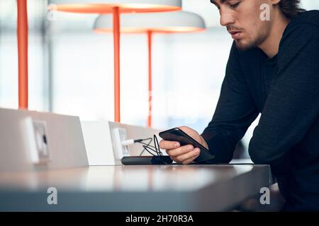 Man using cell phone in library Stock Photo