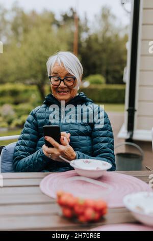 Smiling woman using phone Stock Photo