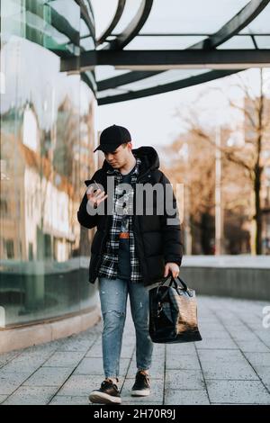 Man looking at his phone while walking Stock Photo
