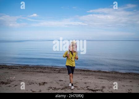 Mother carrying daughter on shoulders Stock Photo