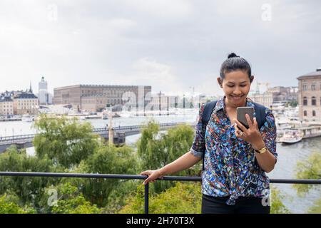 Smiling woman looking at cell phone Stock Photo