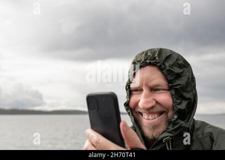 Smiling man using cell phone Stock Photo