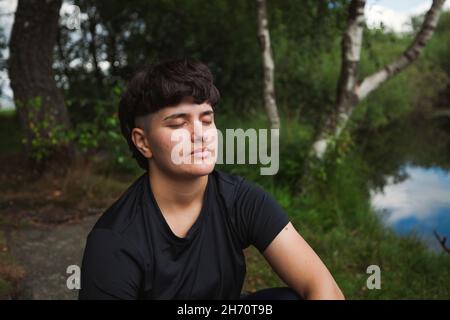 Young woman relaxing at lakeside Stock Photo