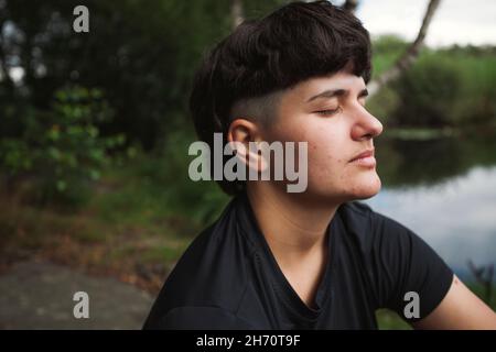 Young woman relaxing at lakeside Stock Photo