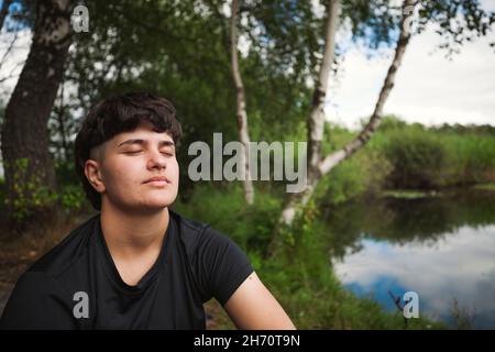 Young woman relaxing at lakeside Stock Photo