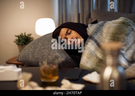 Ill young man sleeping on sofa Stock Photo
