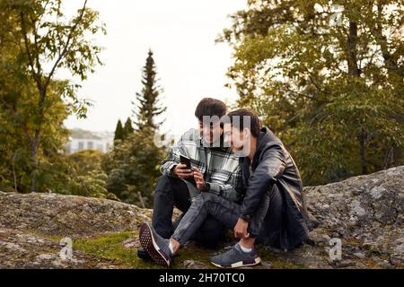 Young men using smart phone outdoors Stock Photo