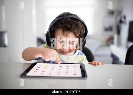 Boy in headphones using digital tablet Stock Photo