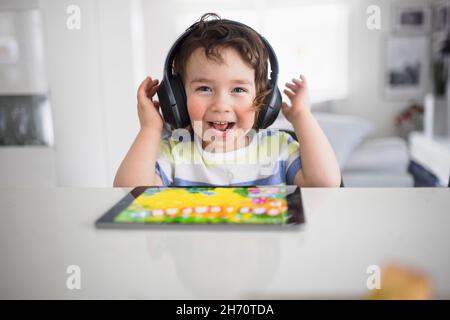 Boy in headphones using digital tablet Stock Photo
