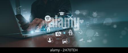 Businessman hand working with modern computer and smart phone show virtual innovation insurance online for car, travel, family and life, financial and Stock Photo