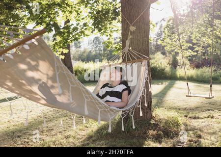 Girl lying in hammock in garden Stock Photo
