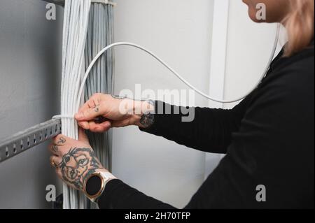 Female electrician managing cables Stock Photo