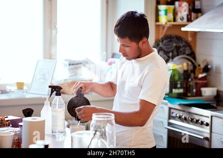 Young man preparing coffee in kitchen Stock Photo