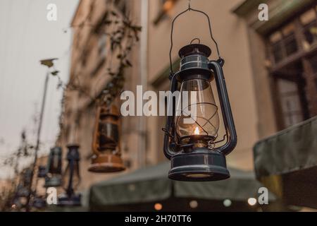 Dark blue kerosene lamp decor with dramatic lighting hanging on the city street in the evening Stock Photo