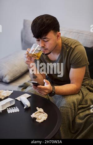 Man on sofa using cell phone Stock Photo